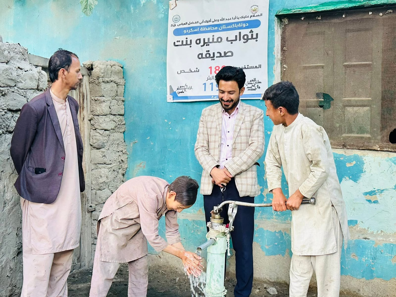 Zafar with community members at a water pump